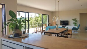 A spacious living room with a large dining table, blue sofa, and a balcony with a view of greenery. - Lorgues Provence Views Comfort Holiday Rest 3 Km from the center! (LorgUes)