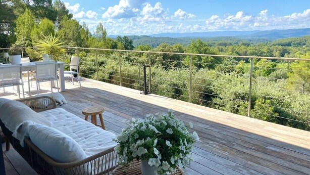 A wooden deck with a wicker sofa and chairs, a small table with a potted plant, and a view of a forested landscape. - Lorgues Provence Views Comfort Holiday Rest 3 Km from the center! (LorgUes)