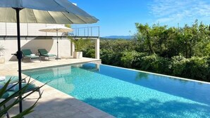 A swimming pool with lounge chairs and umbrellas, surrounded by greenery and a clear sky. - Lorgues Provence Views Comfort Holiday Rest 3 Km from the center! (LorgUes)