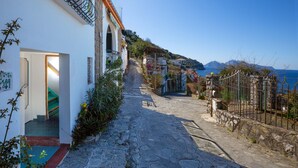 A narrow cobblestone street leading to a building with a staircase and a door. - Estate4home - Bonview suite (Massa Lubrense)