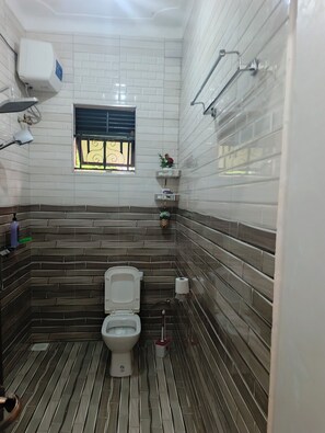 Een douche, handdoeken, zeep, toiletpapier