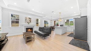 A spacious living area with a fireplace, a black leather sofa, and a dining table. - 4 New Construction in 2024 luxury home 4B/4.5B (Temple City)