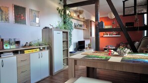 A modern kitchen with wooden cabinets, a dining table, and various kitchen appliances. - Midgard vacation apartment in Sagenharz - Family apartment, 2 bedrooms & WLAN (Thale)