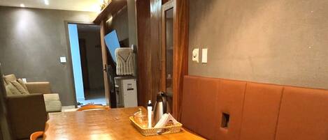 Un comedor con una mesa de madera, sillas anaranjadas y un banco.