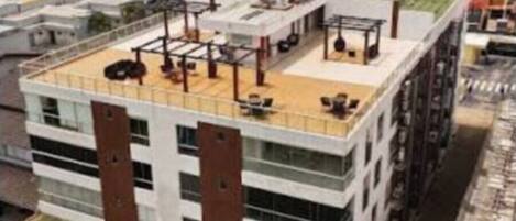A multi-story building with a flat roof, large windows, and a central courtyard.