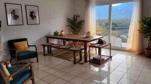 A dining area with a wooden table, chairs, and a view through a large window. - Stunning Annecy lake&mountain views, 3min walk to beach. Great disc. weekly rate (Annecy)