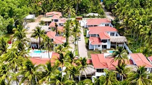 A resort with multiple buildings, a swimming pool, and palm trees. - Beachfront Luxury Villa in Amatecampo Beach, El Salvador (Amatecampo)