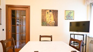 A dining area with a table, chairs, a television, and artwork on the wall. - SE152 - Senigallia, delightful two-room apartment facing the sea (Senigallia)
