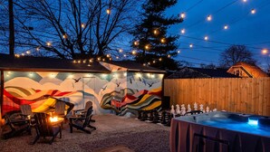 A cozy outdoor patio with Adirondack chairs, a fire pit, and a hot tub. - Lucas Oil Stadium Sanctuary! Hot Tubs! Games! (Indianapolis)