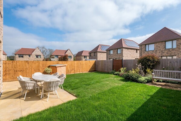 A residential area with a patio, a wooden fence, and houses with solar panels. - Stylish 4-br House - Free Parking Nice Garden (Oxford)