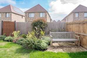A residential area with brick houses, a wooden fence, and a bench in a garden. - Stylish 4-br House - Free Parking Nice Garden (Oxford)