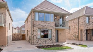 A modern residential building with a brick facade, large windows, and a balcony. - Stylish 4-br House - Free Parking Nice Garden (Oxford)