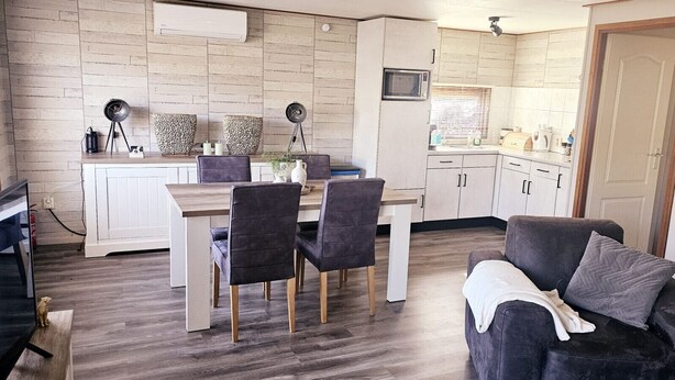 Un espace de vie compact comprenant un coin repas, une kitchenette et un canapé.