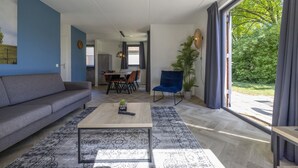 Una sala de estar moderna con un sofá, una mesa de centro y un comedor con sillas y una mesa.