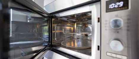 A modern, stainless steel microwave oven with a digital display showing 1029.