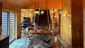 A wooden interior with a dining area, a staircase, and a television. - Lake Vermilion Cabin on a quiet bay with sauna & fire pit for grilling. (Cook)