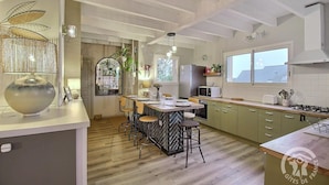 Una cocina moderna con una isla central, taburetes de bar y vistas a la ciudad.