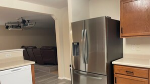 Una cocina compacta con refrigerador de acero inoxidable, gabinetes de madera y lavavajillas integrado.