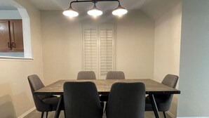 Comedor con una mesa rectangular, seis sillas y una lámpara en el techo.
