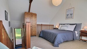 Un dormitorio con cama, armario de madera y vistas al exterior.