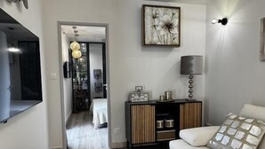 Ein modernes Wohnzimmer mit einer Couch, einem Beistelltisch, einem Schrank und einem Bild an der Wand.