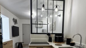 Eine moderne Küche mit Holzausstattung, einem großen Fenster und Pendelleuchten.