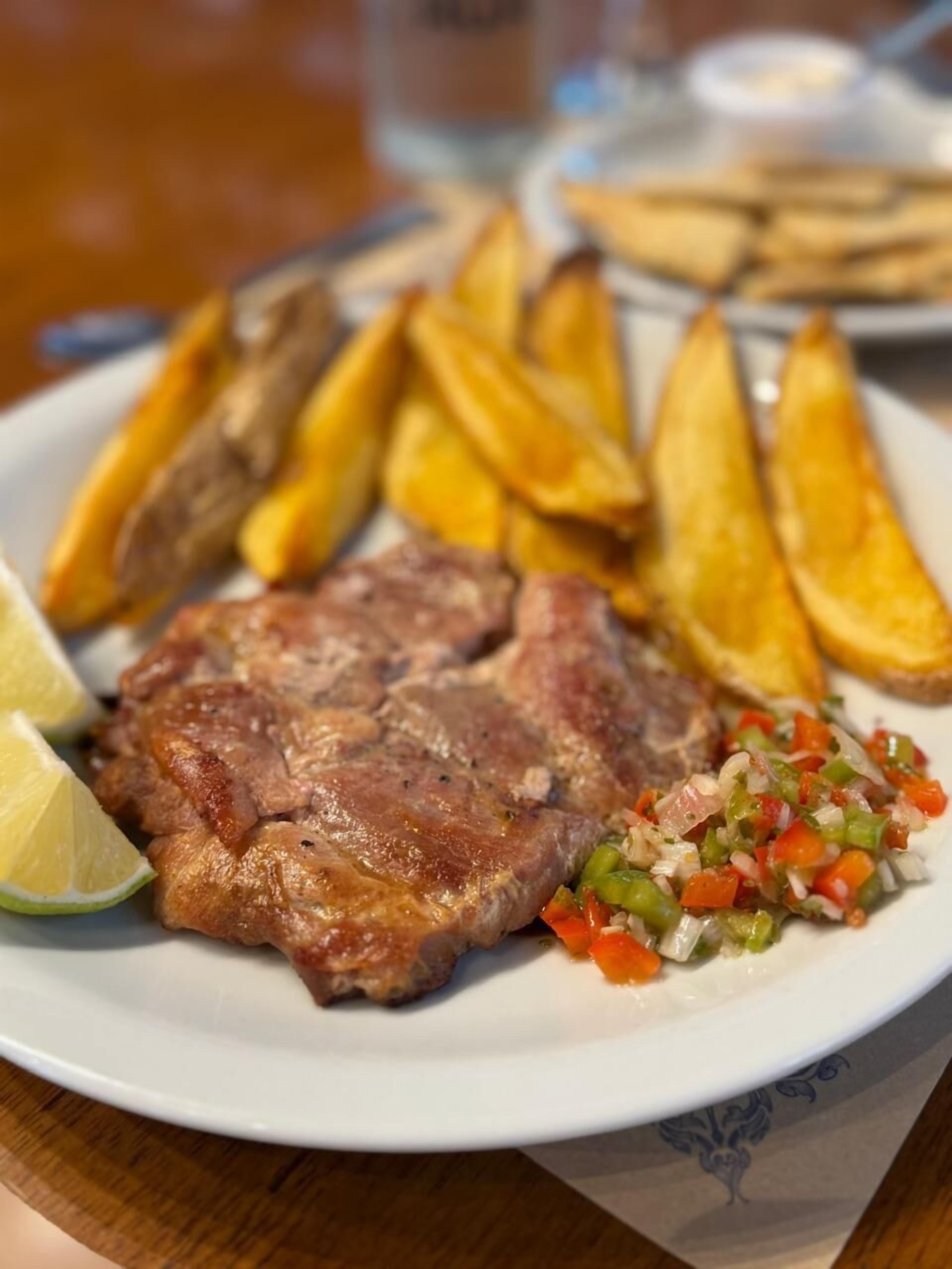 Een bord met steak, friet en een groentemix.