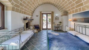 Una habitación con techo de ladrillo, una cama, un escritorio y una silla.