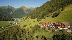 Un complejo turístico de montaña con edificios de estilo chalete, un telesilla y vistas al valle.