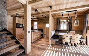 Un interior de madera con cocina, comedor y escalera.