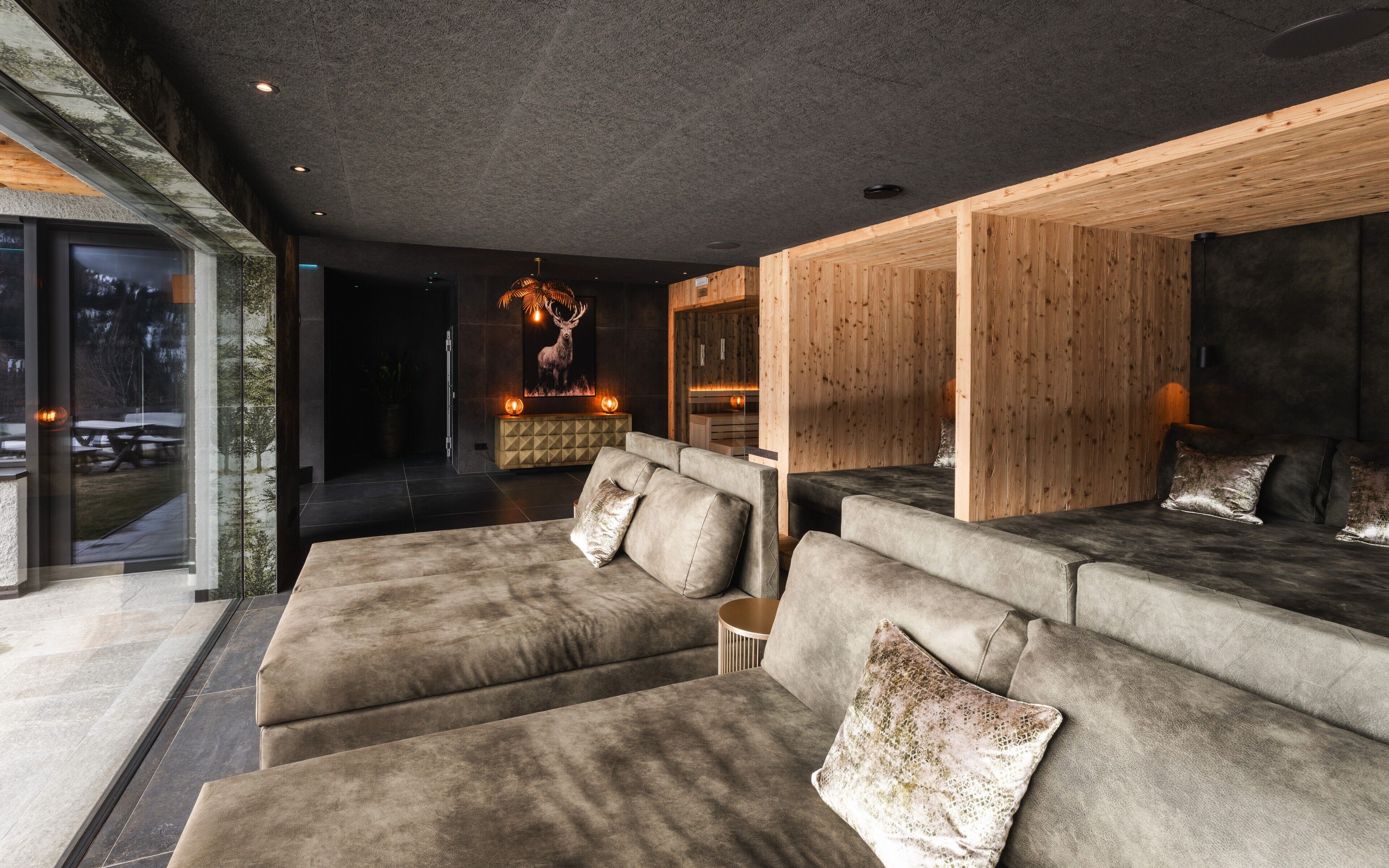 Ein modernes Wohnzimmer mit einer großen Eckcouch, einer Wand aus Holzvertäfelung und einem Kamin.