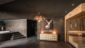 Un interior moderno con un mostrador de recepción de madera, un reloj de pared, una obra de arte con ciervos enmarcada y una escalera que lleva a una zona de estar.