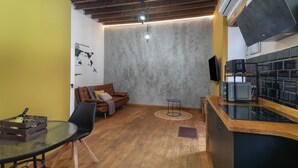 A compact kitchen with a wooden countertop, a built-in stove, and a small dining area with a table and chairs.