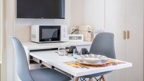 Uma cozinha compacta equipada com micro-ondas, torradeira e máquina de café.