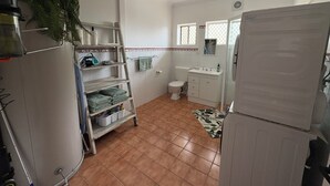 Une cuisine de taille réduite, équipée d’un réfrigérateur, d’un évier et d’une petite fenêtre.