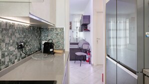 Eine moderne Küche mit gefliestem Rückspritzschutz, einem eingebauten Backofen und einem Kühlschrank mit Glastür.