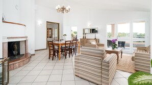 A spacious living area with a fireplace, dining table, and comfortable seating.