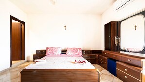 A bedroom with a large bed, wooden headboard, a wardrobe, a mirror, and a cross on the wall. - Apartment 'Baldi' with Private Terrace, Wi-Fi and Air Conditioning (Otranto)