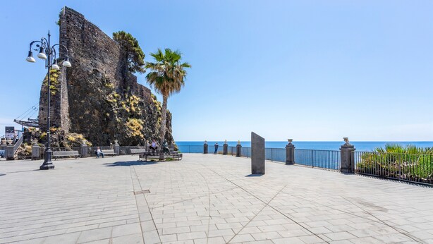 A paved promenade with a stone wall, palm trees, and a view of the sea. - Apartment 'Holiday Home Castello' with Sea View, Wi-Fi and Air Conditioning (Aci Castello)