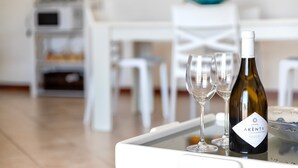 A bottle of Akenta wine on a table with two glasses.