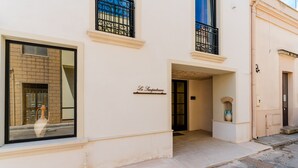 A building with a sign reading 'Le Sanpietroane,' a door, and a small decorative item on the ground. - Room 'Li Parate' with Shared Terrace, Wi-Fi and Air Conditioning (Taviano)