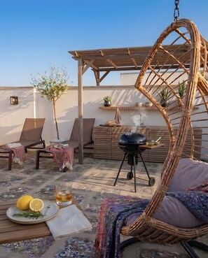 An outdoor patio with a grill, lounge chairs, and a hanging chair. - Room 'Li Parate' with Shared Terrace, Wi-Fi and Air Conditioning (Taviano)