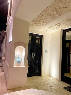 A hallway with a black door, a white wall, and a tiled floor. - Room 'Li Pumi' with Shared Terrace, Wi-Fi and Air Conditioning (Taviano)