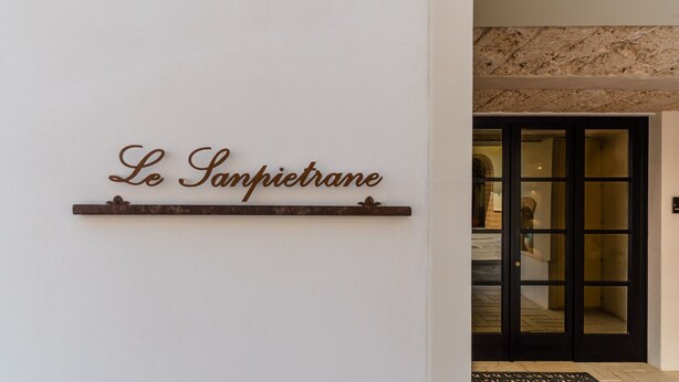Une enseigne portant l’inscription « Le Samptierane » est fixée à un mur.