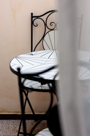 A chair with a geometric pattern on the seat and backrest, positioned against a wall. - Room 'Li Pumi' with Shared Terrace, Wi-Fi and Air Conditioning (Taviano)