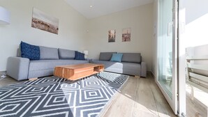 A modern living room with a grey sofa, a wooden coffee table, and patterned rugs. - Villa 'Sanctipetri 10 Pax – adults over 25 only' with private pool, Wi-Fi & air conditioning (Chiclana de la Frontera)