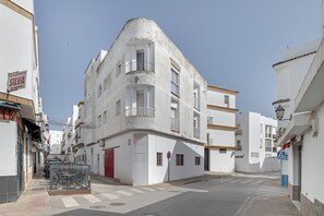 A narrow street with white buildings, a red door, and a sign for 'Electrodomesticos Silva'. - Apartment 'Antonia Conil' with Shared Terrace, Wi-Fi and Air Conditioning (Conil de la Fra.)