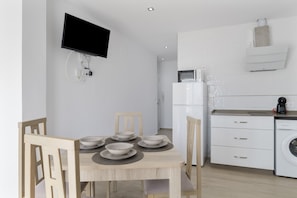Una cocina moderna con armarios blancos, un microondas y una lavadora.
