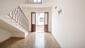 A spacious hallway with a polished stone floor, a metal staircase with a geometric railing, and a door leading to an outdoor area. - Holiday Home 'Residenza Della Riva Blu' with Sea View, Shared Terrace and Air Conditioning (Porto Cesareo)