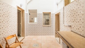 A bathroom with patterned tiles, a wooden bench, a window, and a sink. - Holiday Home 'Residenza Della Riva Blu' with Sea View, Shared Terrace and Air Conditioning (Porto Cesareo)